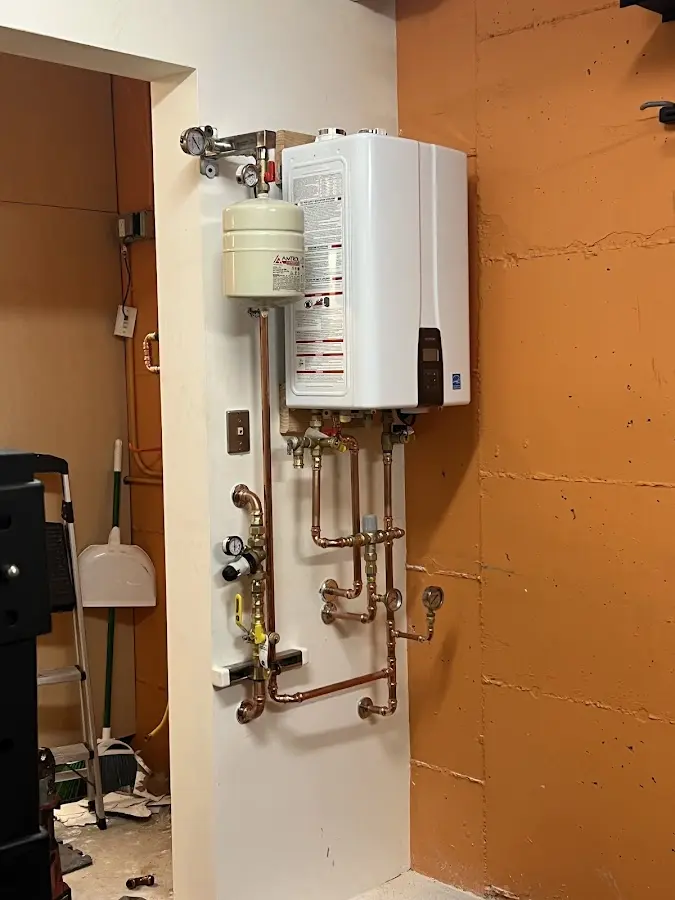 Plumbing technician inspecting water heater connections in Wildwood